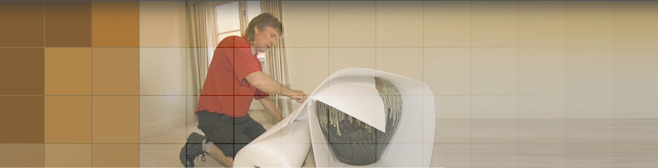 Man bubble wrapping up a large vase